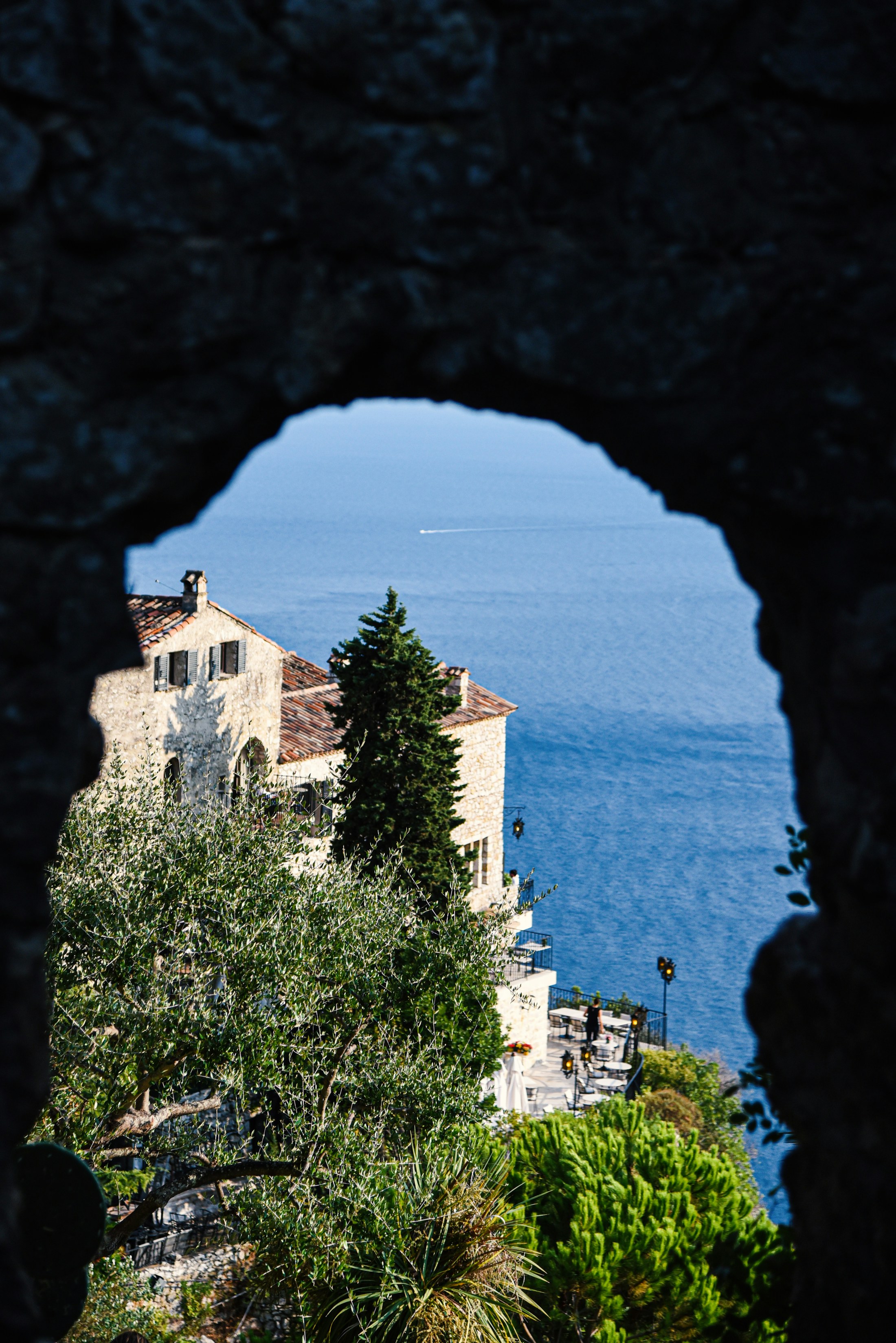 Limestone villa framed by an arch above the Mediterranean